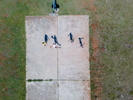 Aerial shot of people playing basketball on an outdoor court in Bethelsdorp, South Africa.