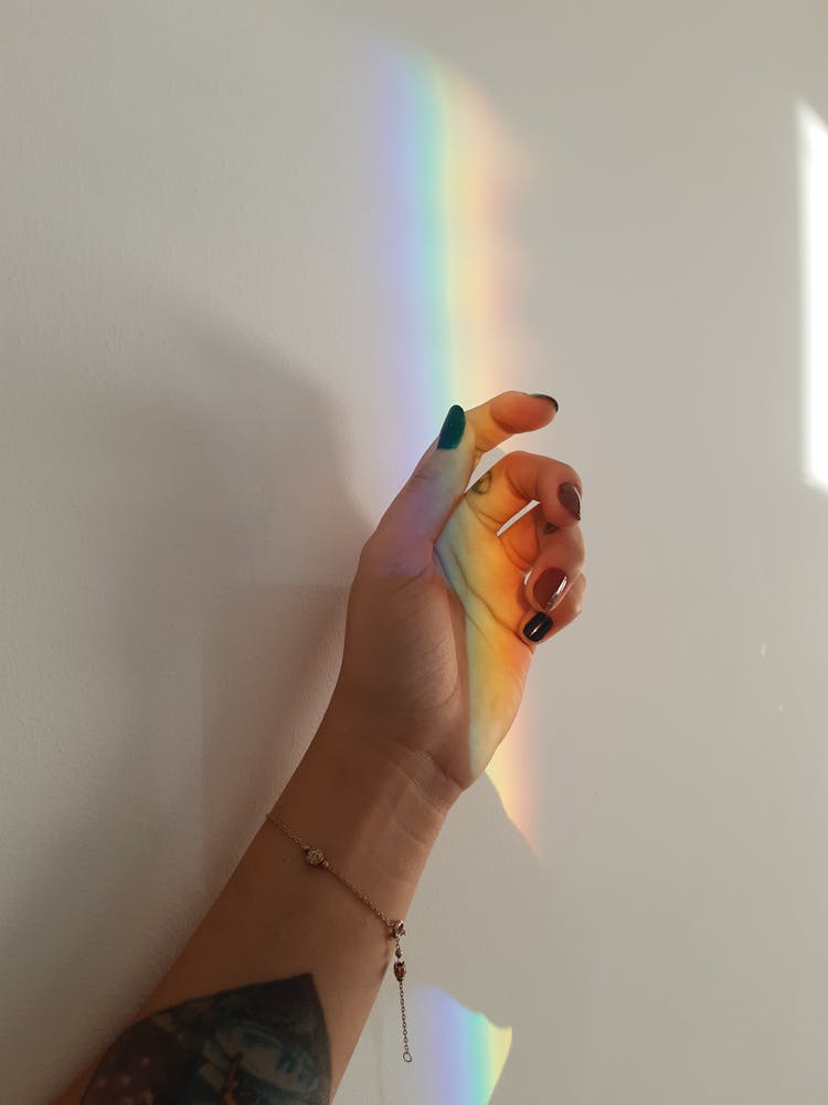 Faceless Woman Near White Wall With Rainbow