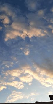Low angle scenic view of blue sky with fluffy clouds above construction in twilight