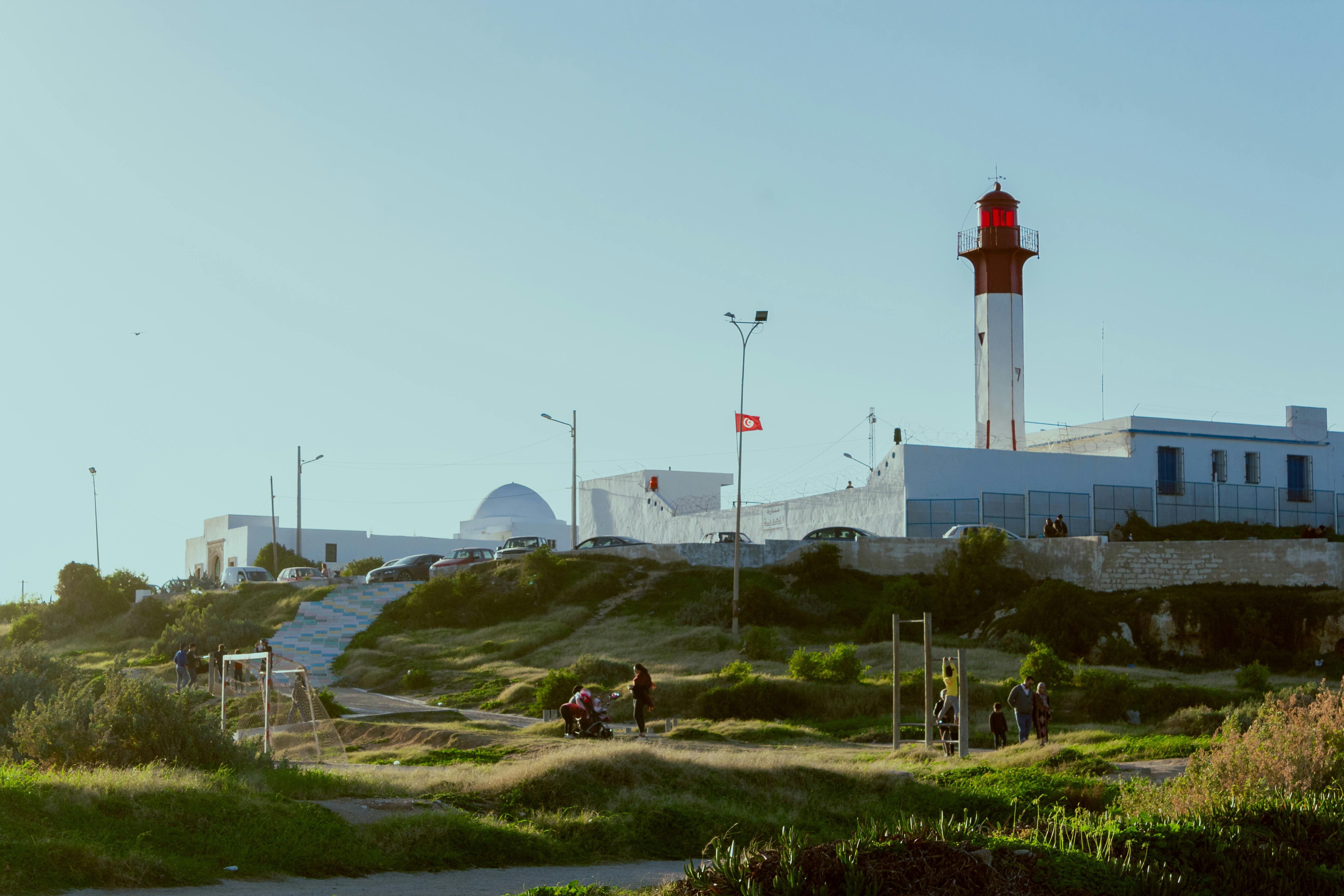 Explore the iconic Sidi Bou Said Lighthouse with people enjoying the scenic view. - Sidi Bou Said