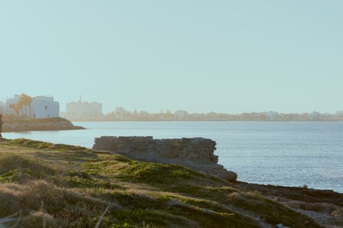 Free A serene coastal cityscape with calm waters at sunrise, capturing a peaceful urban waterfront. Stock Photo