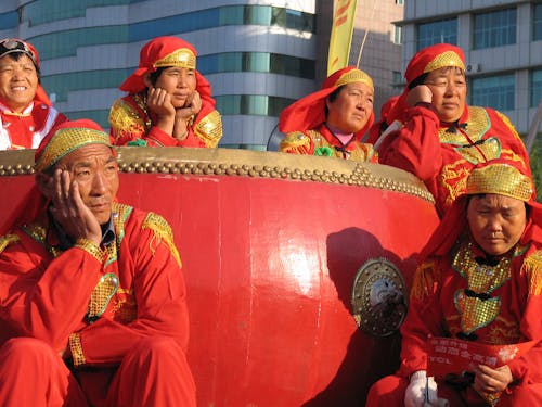 People Sitting and Standing Together on Float on Street Parade