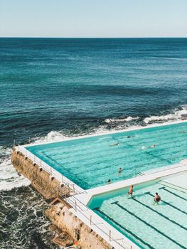 Stunning aerial shot of Bondi Icebergs pool with ocean waves crashing, a top Sydney tourist attraction.