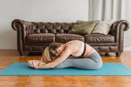 A young woman stretching on a yoga mat indoors, fostering relaxation and fitness.