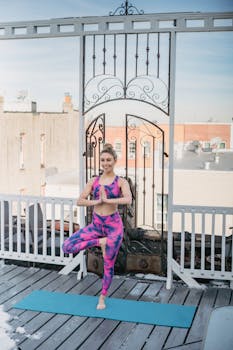 Woman in vibrant activewear practices yoga on a rooftop, embracing mindfulness and balance.