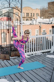 Woman practicing yoga on a snowy rooftop terrace. Focused and flexible.