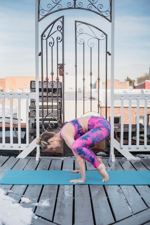 Strong woman doing Crow asana on street