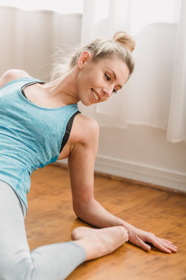 Young Sportive Woman Leaning Back While Sitting On Floor