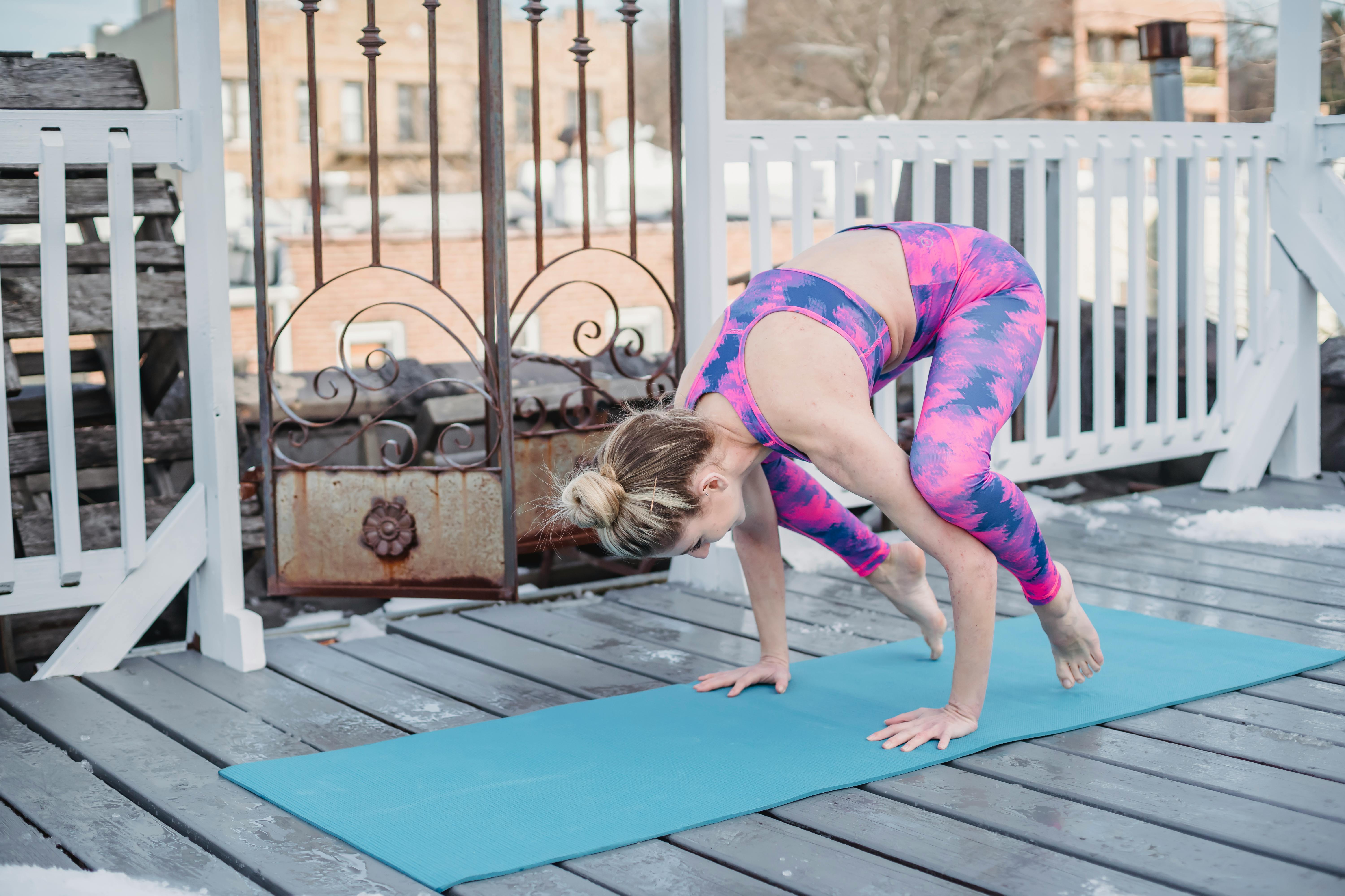 Slim flexible sportswoman doing yoga in Crow pose