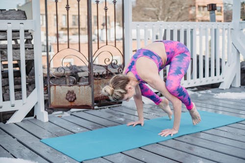 Slim flexible sportswoman doing yoga in Crow pose