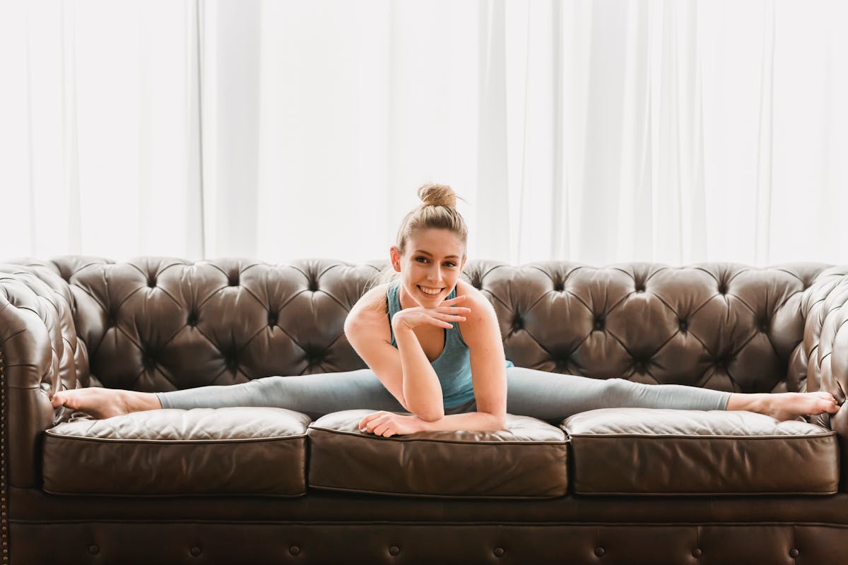 Happy woman stretching legs on sofa