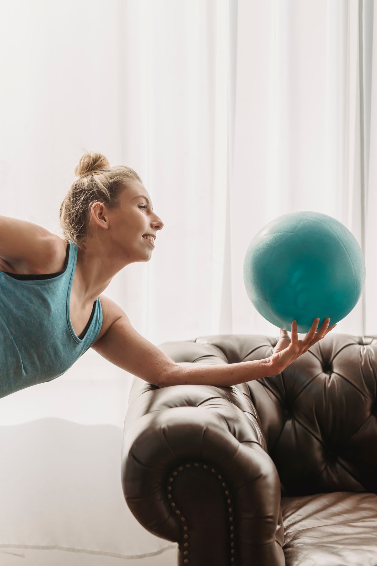Smiling woman exercising with a fitness ball