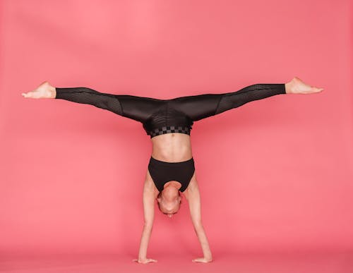 Free Flexible woman stretching legs while standing on hands Stock Photo