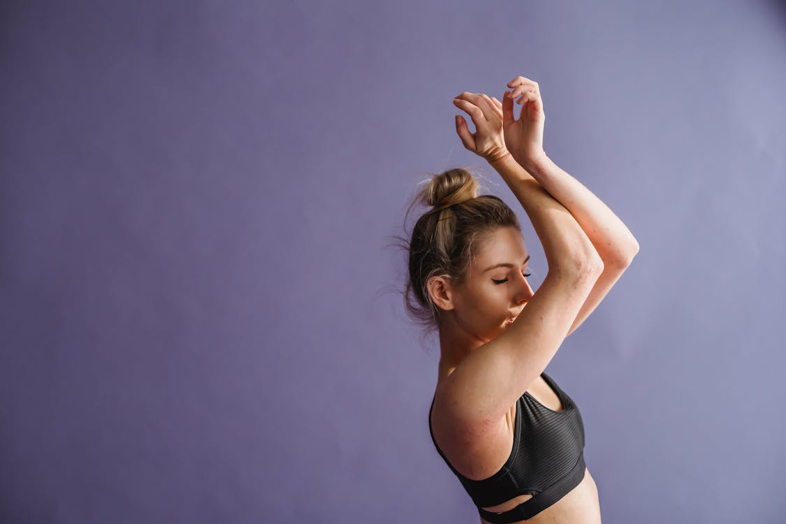 Free Female dancer standing with raised arms Stock Photo