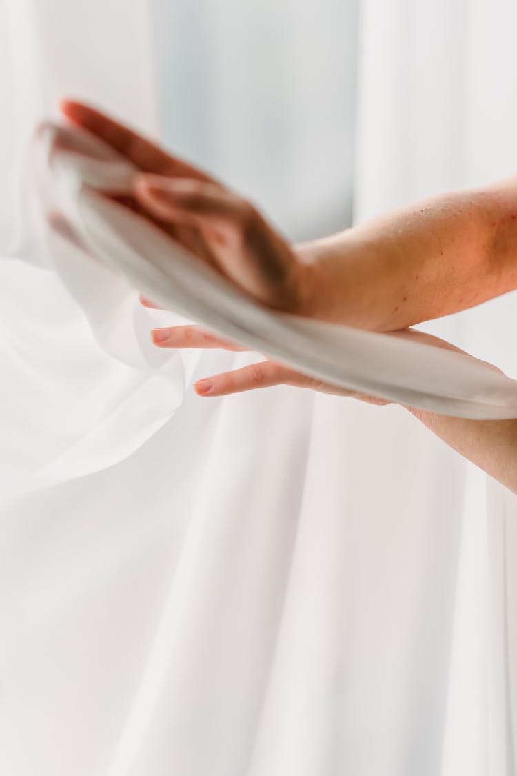 Crop Woman Touching White Curtain