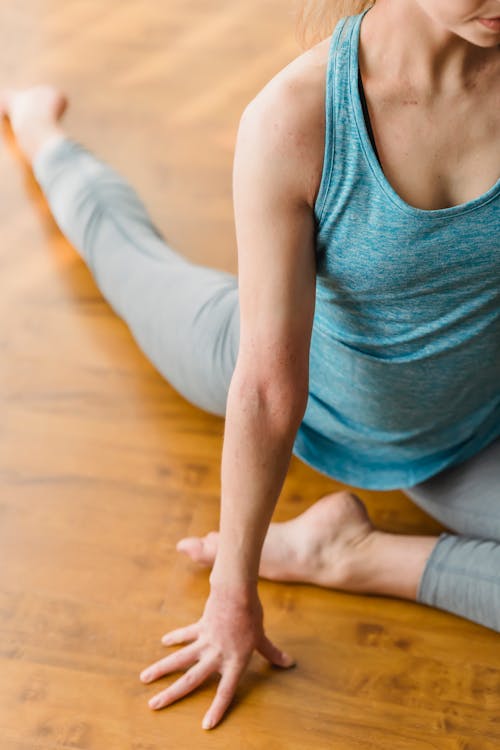 Woman in activewear doing pigeon pose on floor