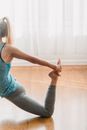 Side view of crop fit anonymous female doing yoga in One Legged King Pigeon pose ll in daylight