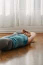 Sportive woman doing Extended supine hand to toe asana