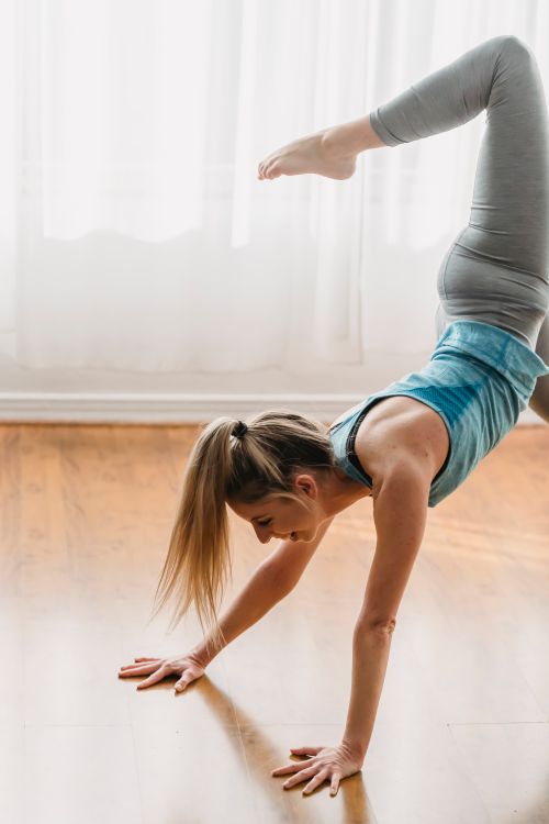 Free Side view of sportive female in practicing Three legged downward facing dog with hip opener asana during yoga training at home Stock Photo