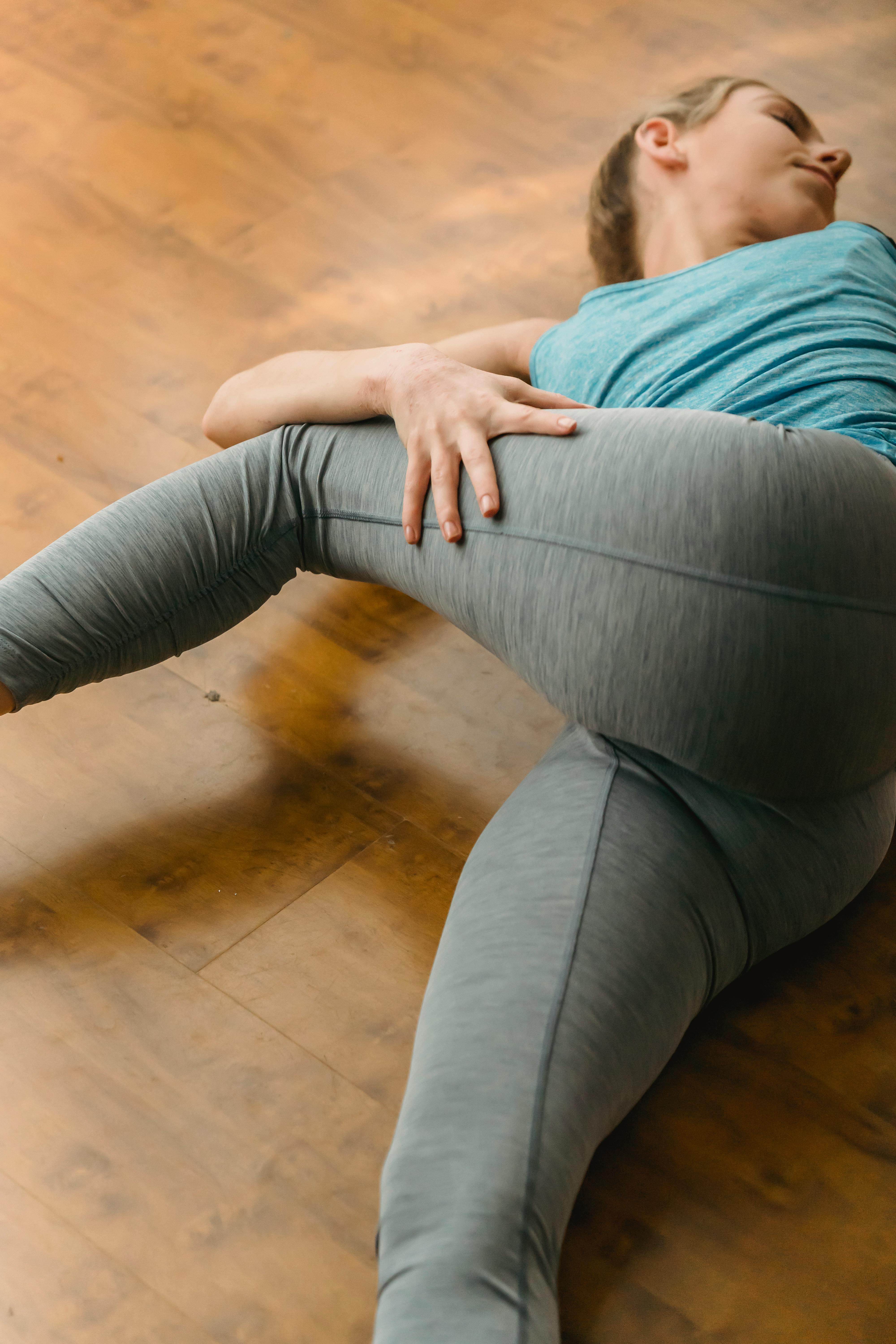 fit young woman doing stretching exercise on floor