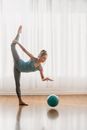Woman with raised leg hitting ball on floor