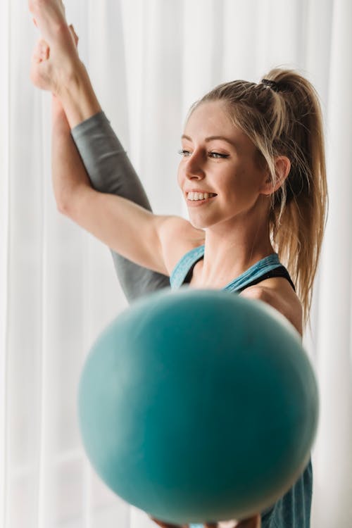 Cheerful woman stretching with gymnastic ball · Free Stock Photo