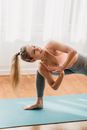 Smiling woman doing yoga in Revolved Crescent Lunge on Knee pose with prayer hands