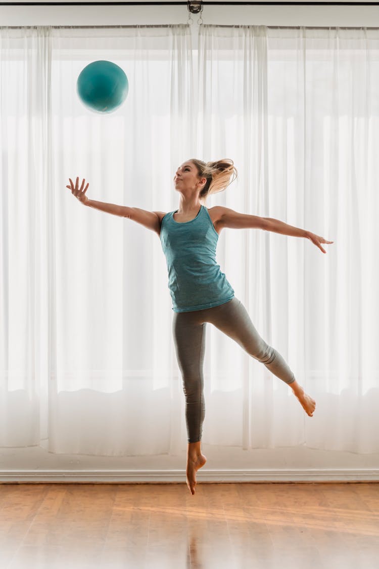 Slim Woman Jumping Up With Ball