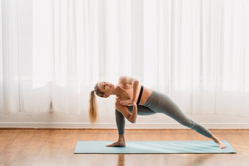 Barefooted lady stretching body in Parsvakonasana