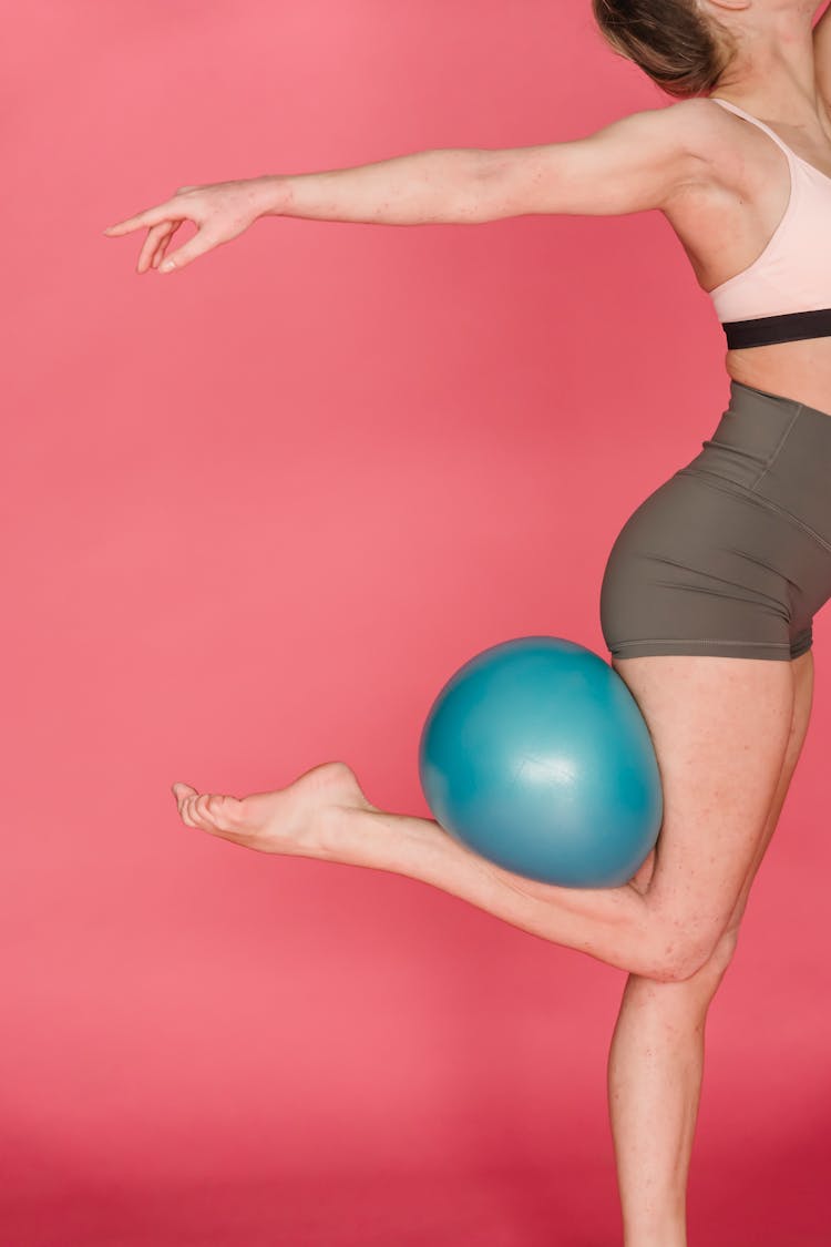 Slim Woman Doing Gymnastic Trick With Ball