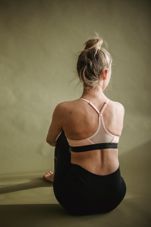 Peaceful woman in sportswear sitting in studio