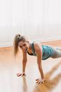 Laughing woman practicing Plank posture during training