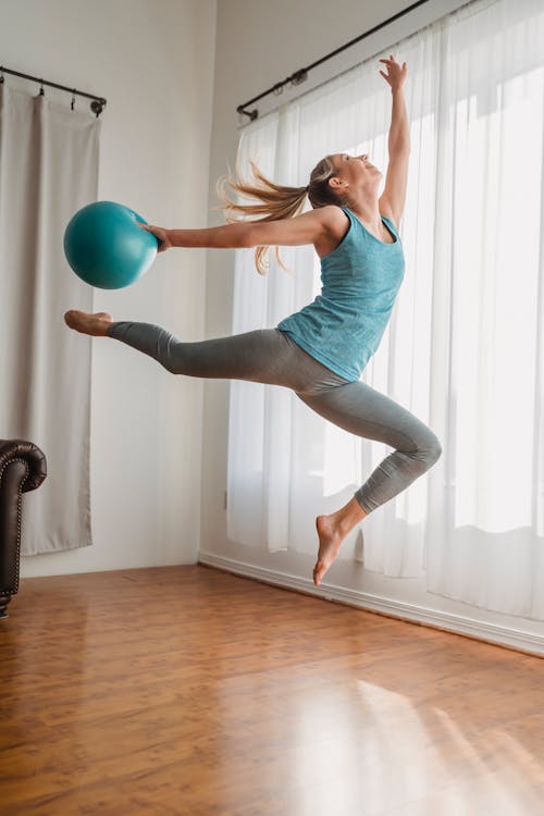 Woman jumping with fitness ball