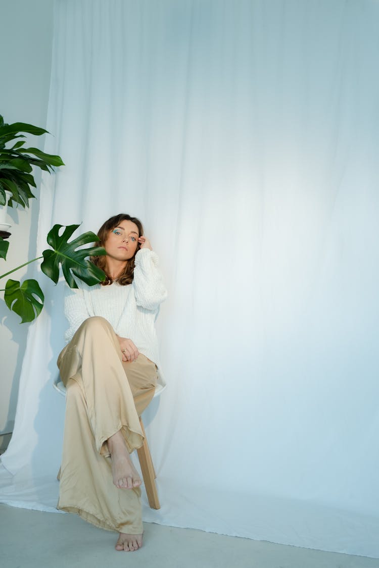 Woman Posing Wearing White Knitted Sweater And Khaki Pants 