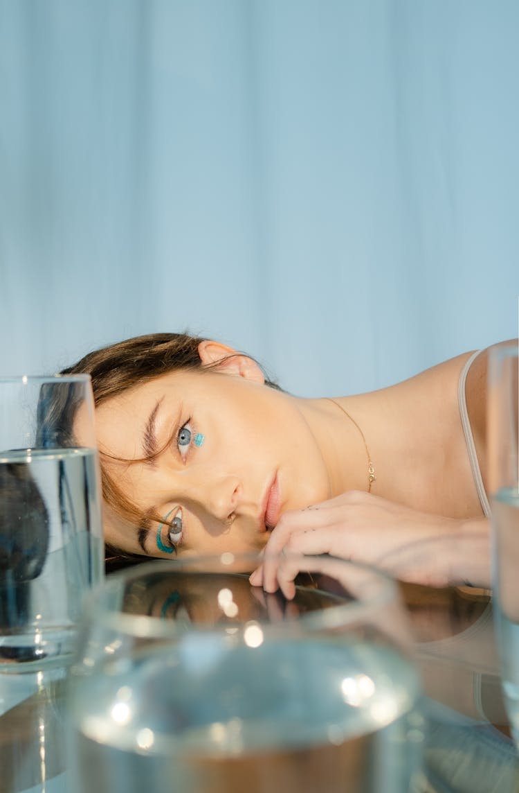 Woman Face Laying On A Glass Table