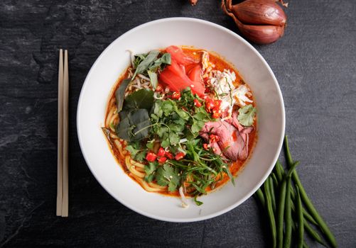 Delicious Asian noodle soup with beef and fresh herbs, perfect for a spicy meal.