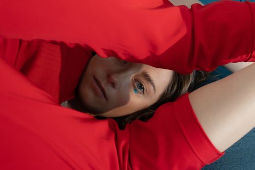 Free Artistic portrait of a woman in red clothing with captivating blue eyes, set indoors. Stock Photo