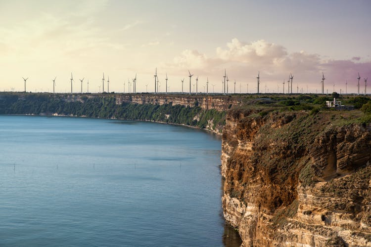 Cape With Windmills Near Calm Sea