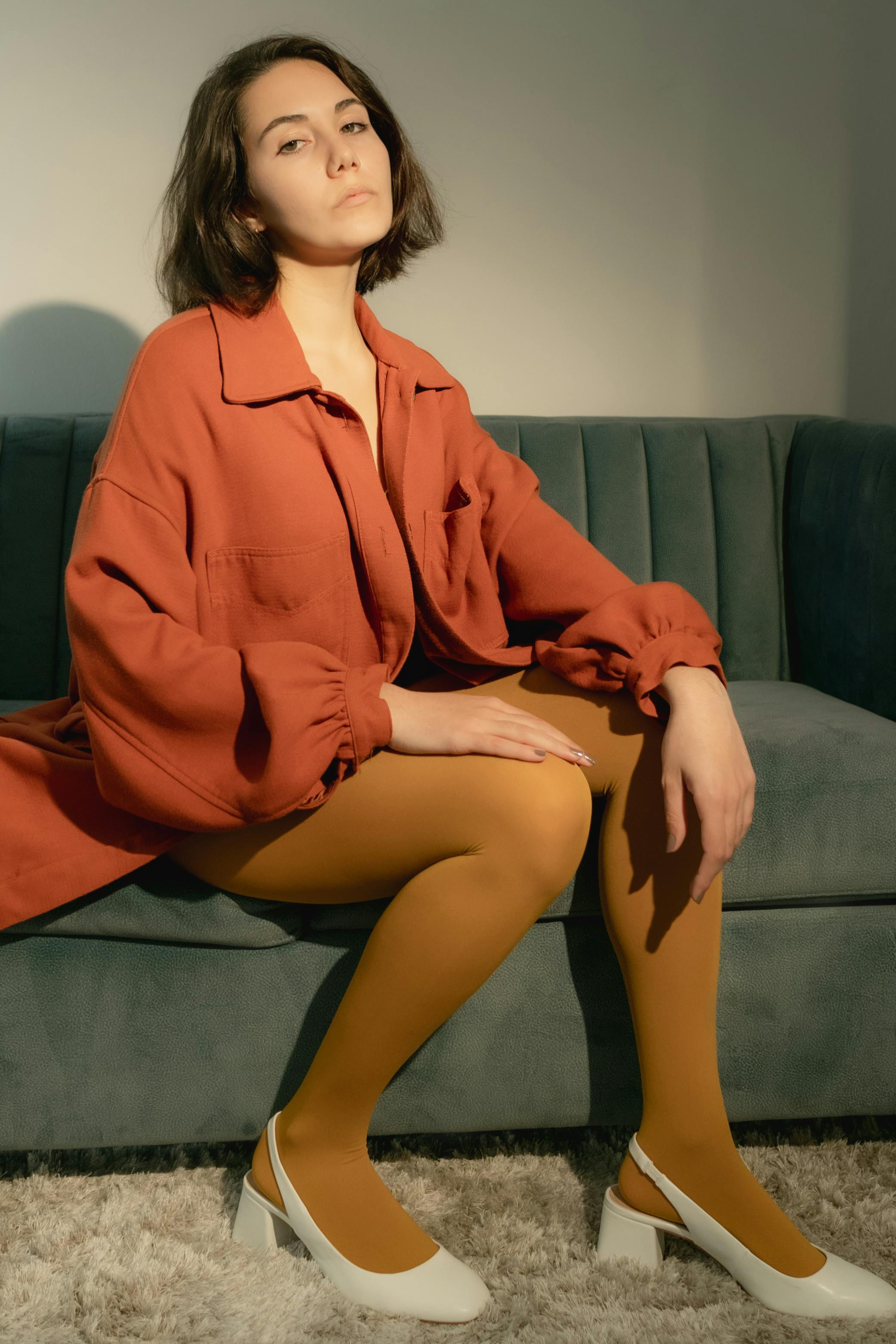 woman in red long sleeve shirt sitting on green couch