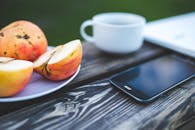 Mobile phone, apple, coffee on the wooden table