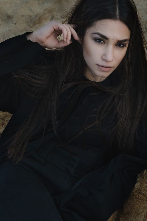 Free Striking portrait of a woman in black clothing posing outdoors. Stock Photo