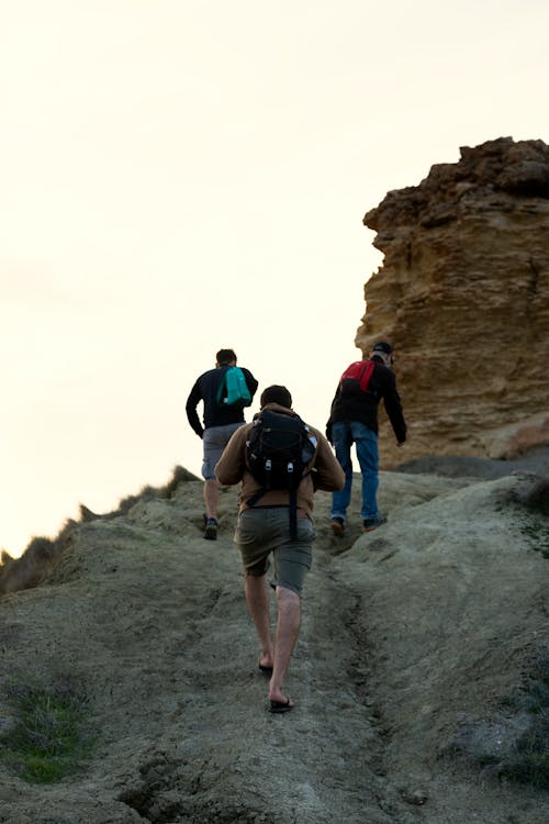 黑色的t恤和棕色的短褲，背著背包走在落基山上的男人
