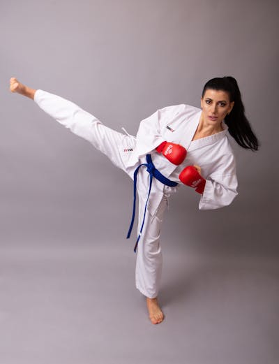 Karateka performing high kick demonstrating balance and martial arts discipline