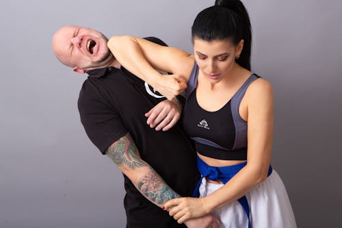 Free A Woman in Sportswear Demonstrating an Elbow Strike with a Man Stock Photo