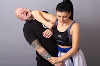 Man in Black Tank Top and Blue Shorts Sitting on Mans Lap