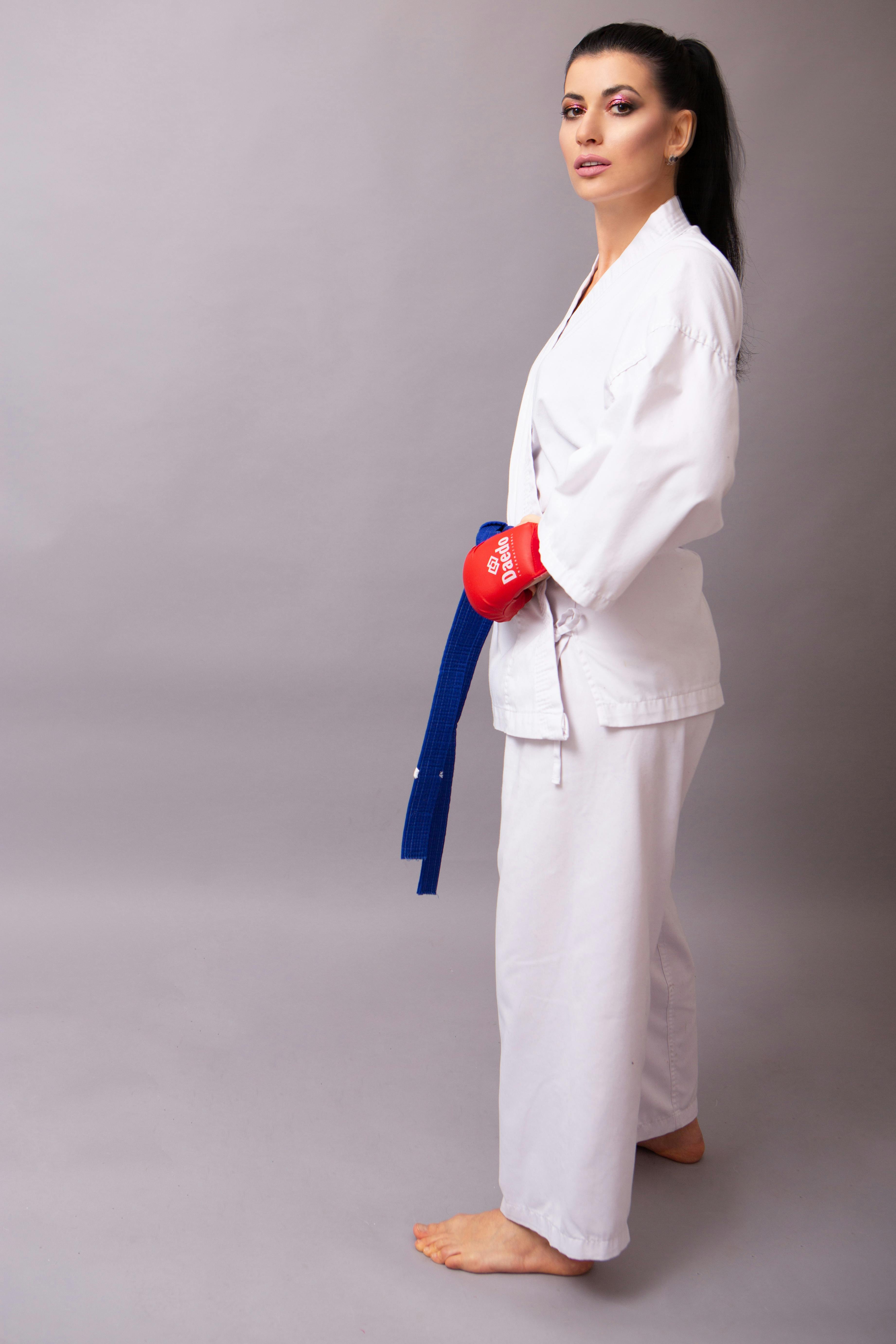Self assured sportswoman in karate uniform on gray background · Free