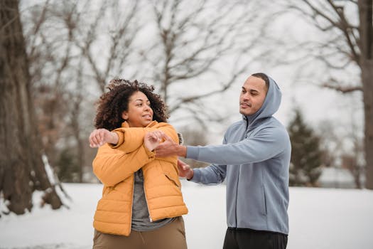 Two adults engage in a motivating winter workout session outdoors, focusing on stretching.