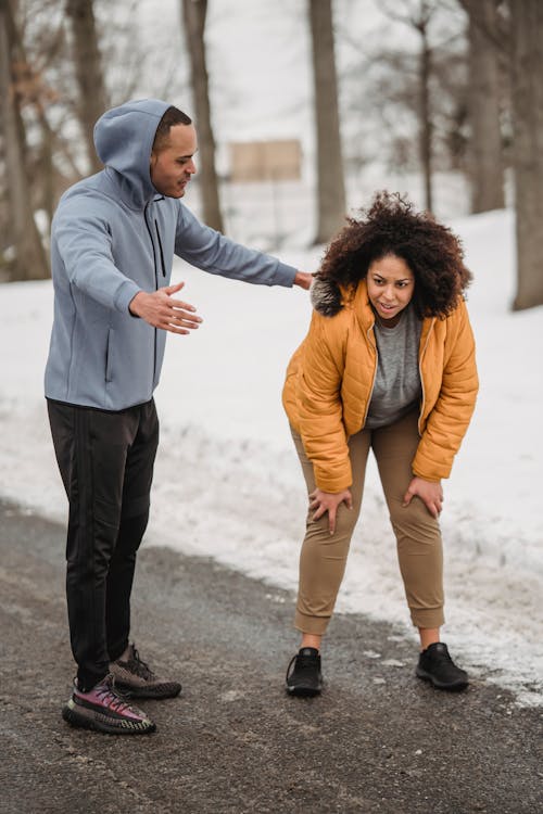 Tired black woman having break in run training with coach