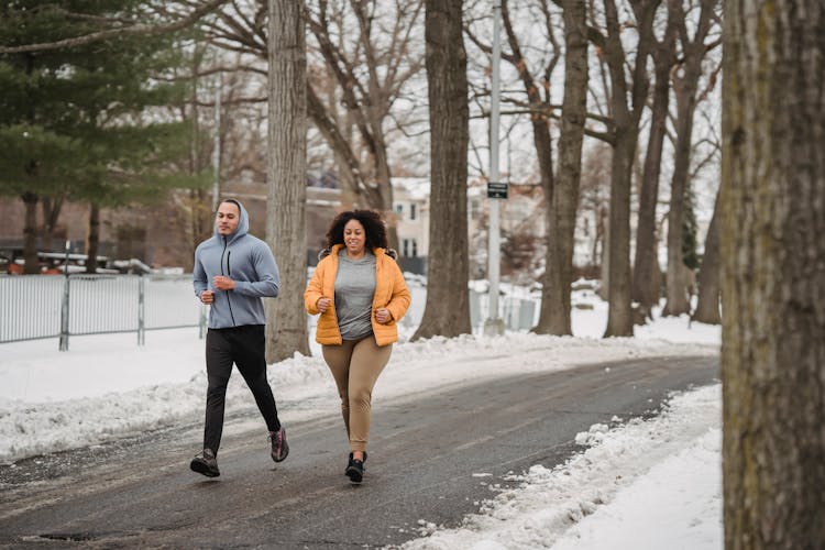 Active Black Trainer Running With Woman In Snowy Winter Day