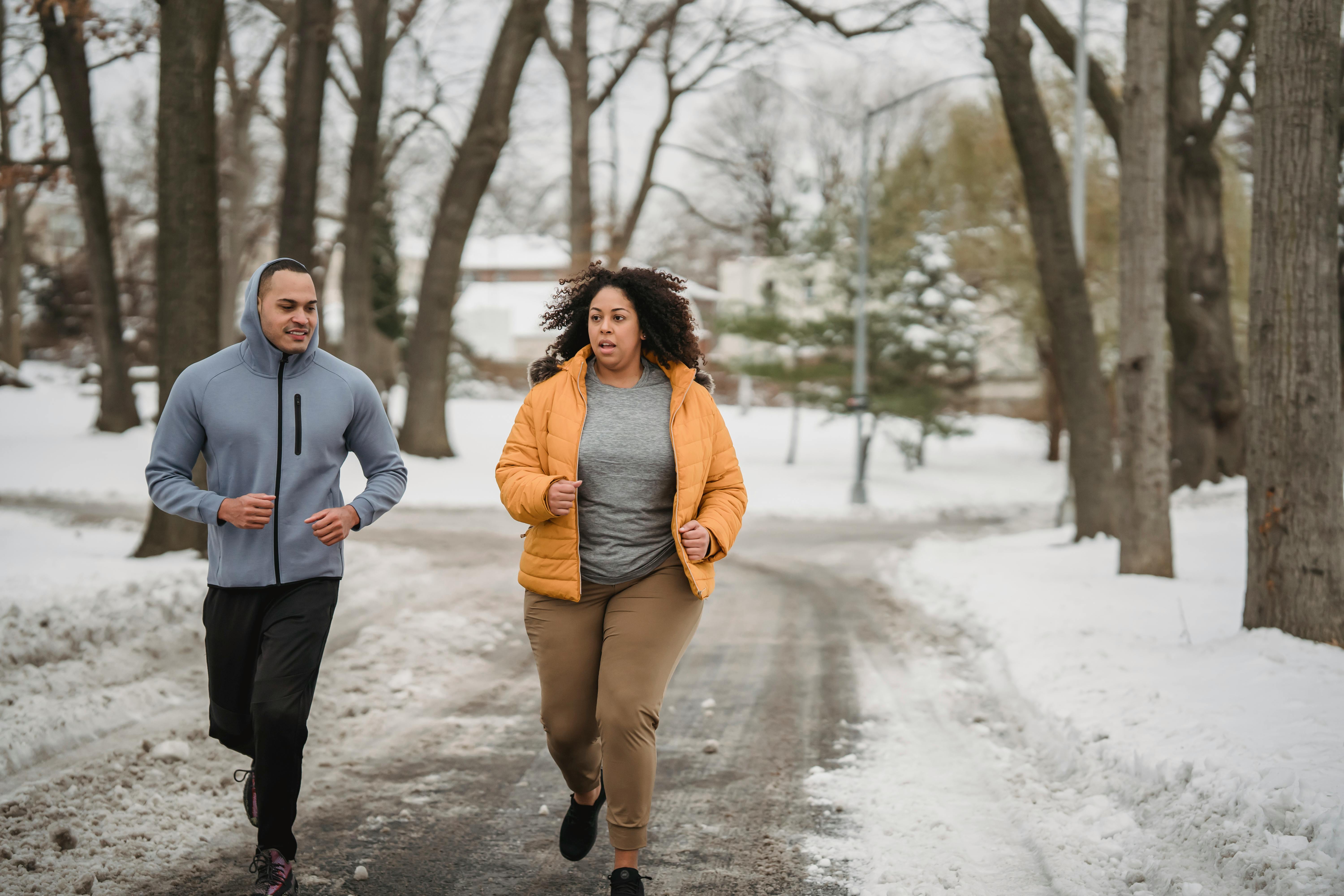 overweight black woman running with trainer on snowy road
